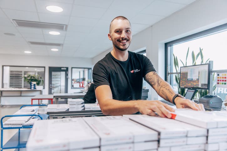 Arbetare som ler vid utleveransstation